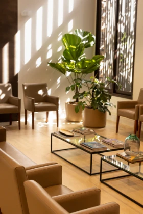 Recepção com poltronas, mesas de vidro e iluminação natural